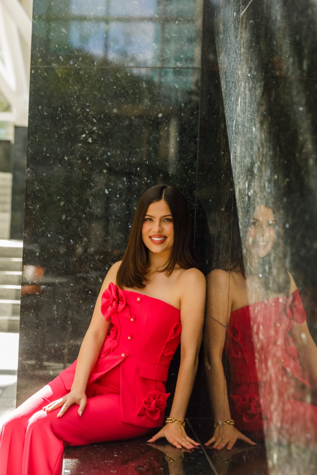 Cristina Luckey beside a reflective marble wall